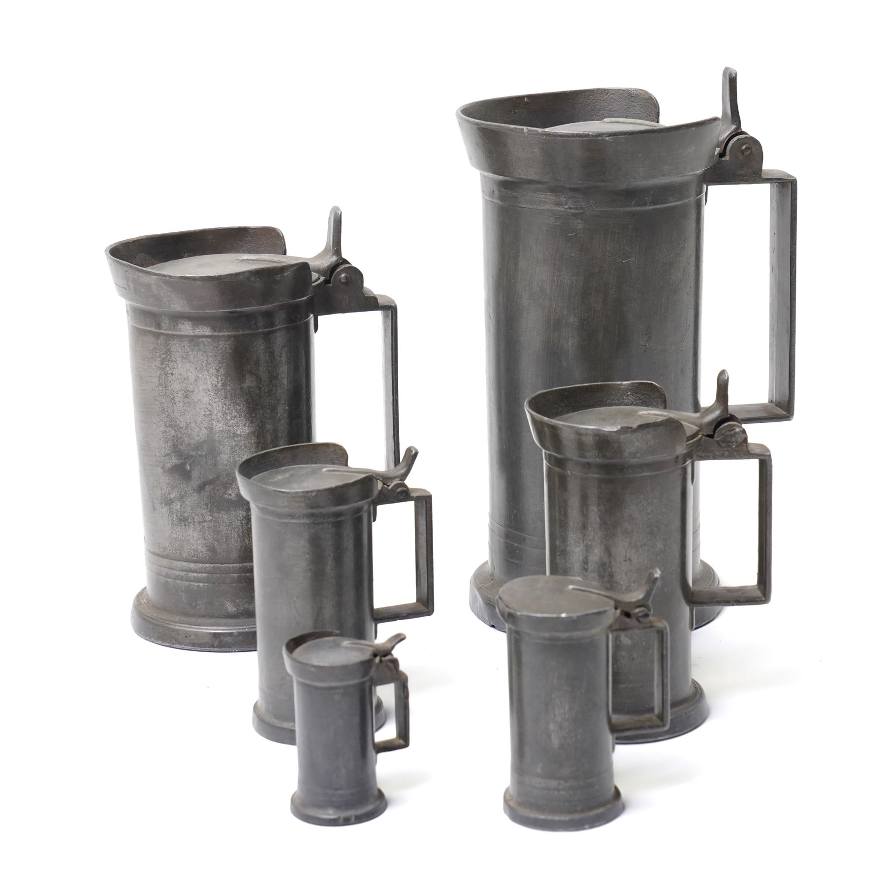 Set of six Continental 19th century graduated pewter lidded measures, each of cylindrical form with touch marks to base, max H22cm 