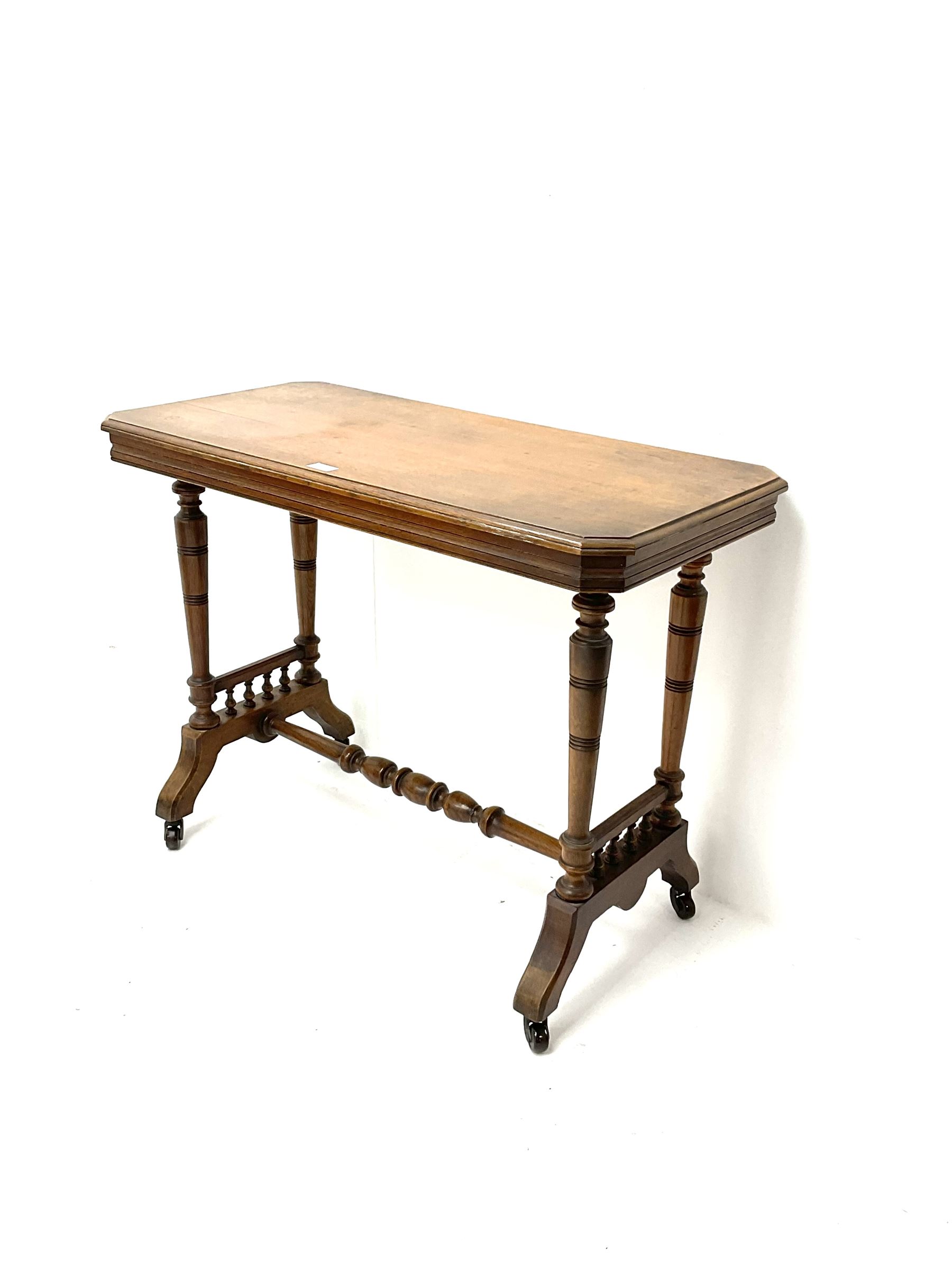 Late Victorian oak side table, moulded top, bobbin turned supports and stretcher, shaped feet and castors
