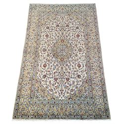 Fine Persian Kashan rug, ivory ground with central medallion surrounded by interlacing foliage and stylised flower heads, the guarded border decorated with scrolling floral design, outer guard signed 