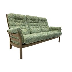Ercol - ash framed three seat sofa (W193cm, H96cm, D85cm), and pair of matching armchairs (W81cm), with upholstered loose cushions in green foliage patterned fabric 