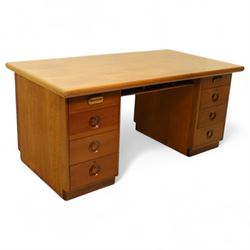 Mid 20th century teak twin pedestal partners desk, rectangular top with rounded corners with integral frieze storage shelf, above  pedestals each fitted with three drawers, recessed circular pull handles, cupboard doors fitted to the opposing side on concealed plinth bases