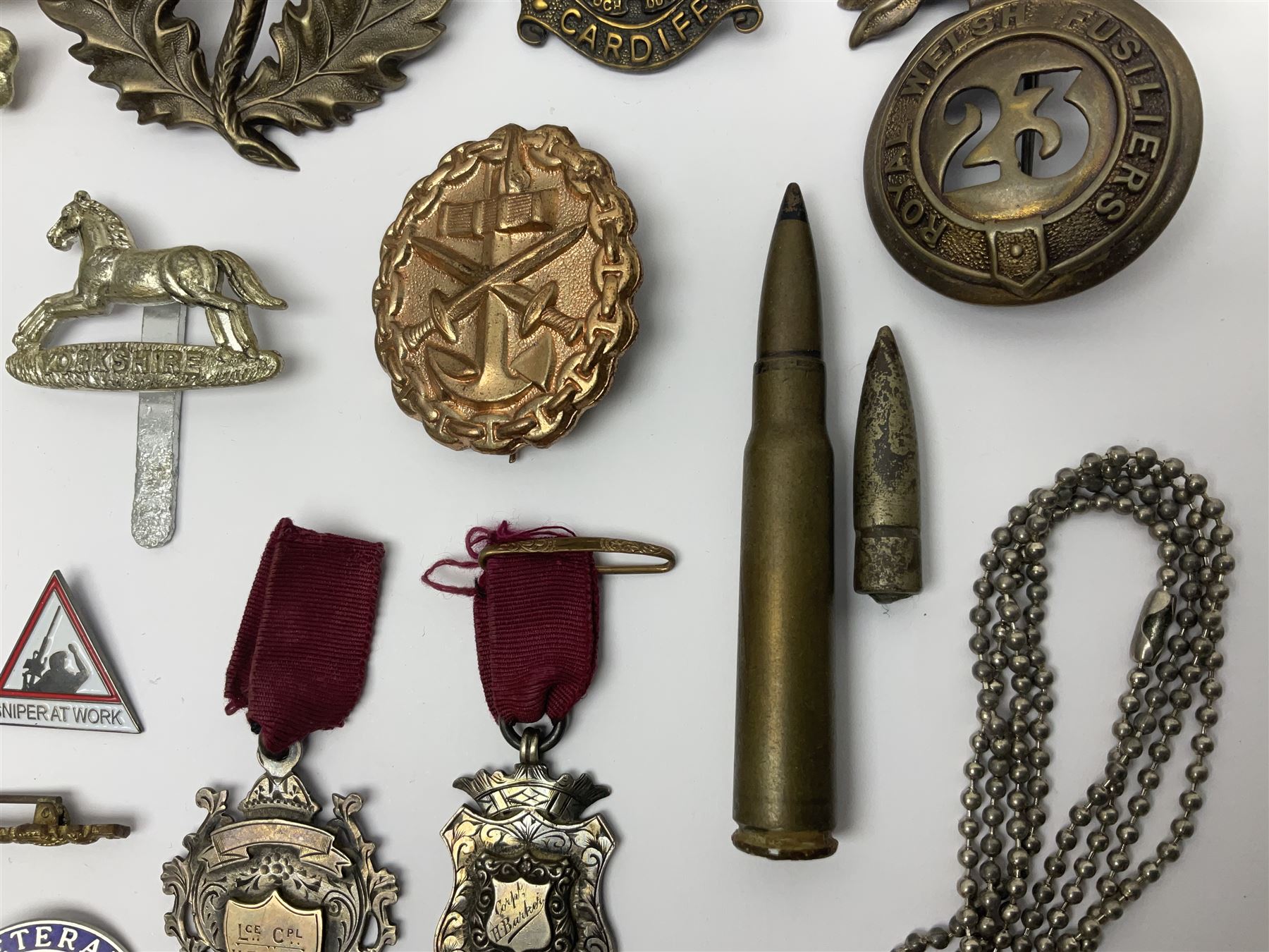 Two Edwardian hallmarked silver presentation fobs for military bugling competitions; and quantity of cap/glengarry and other badges, sweetheart brooches etc