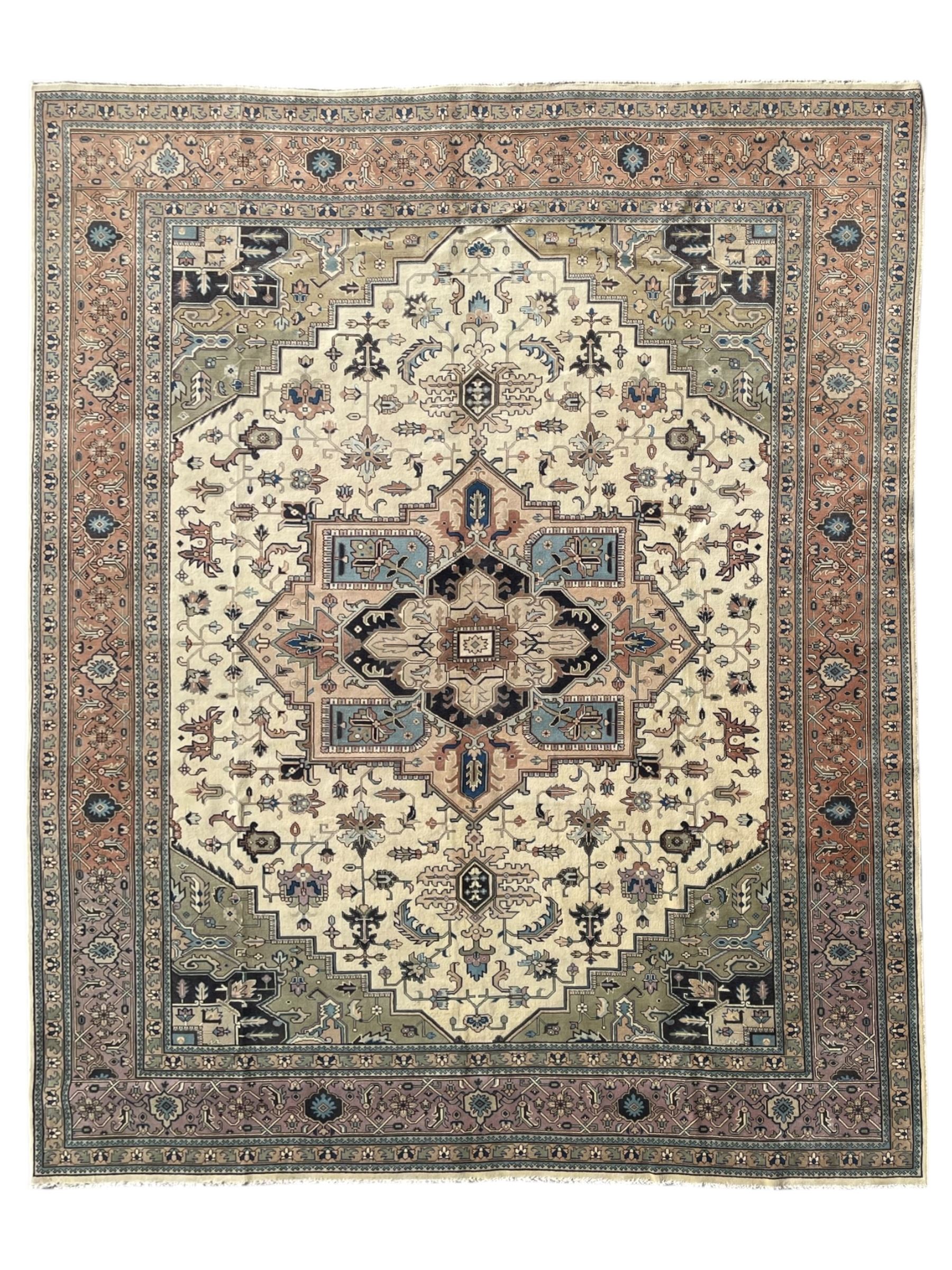 Persian Heriz pale olive and ivory ground carpet, large quatrefoil medallion with palmettes, the surrounding field decorated with trailing leafy branches and stylised plant motifs, peach ground borders with overall floral pattern, within guard stripes 