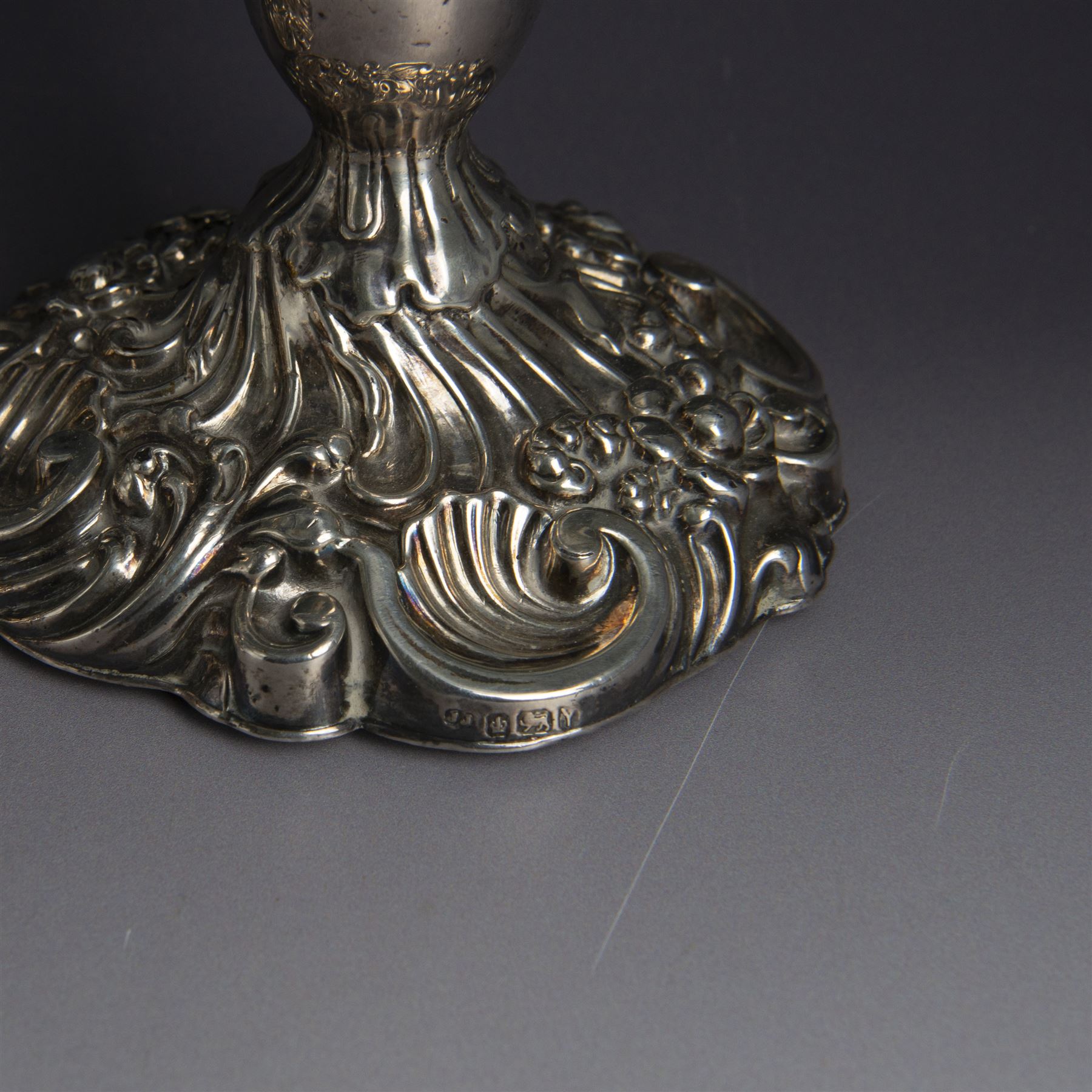 Pair of late Victorian silver candlesticks, each embossed wth floral, foliate and scrolling decoration, with removable sconces and upon a weighted embossed base, hallmarked Jenkins & Timm, Sheffiled 1891, H20cm