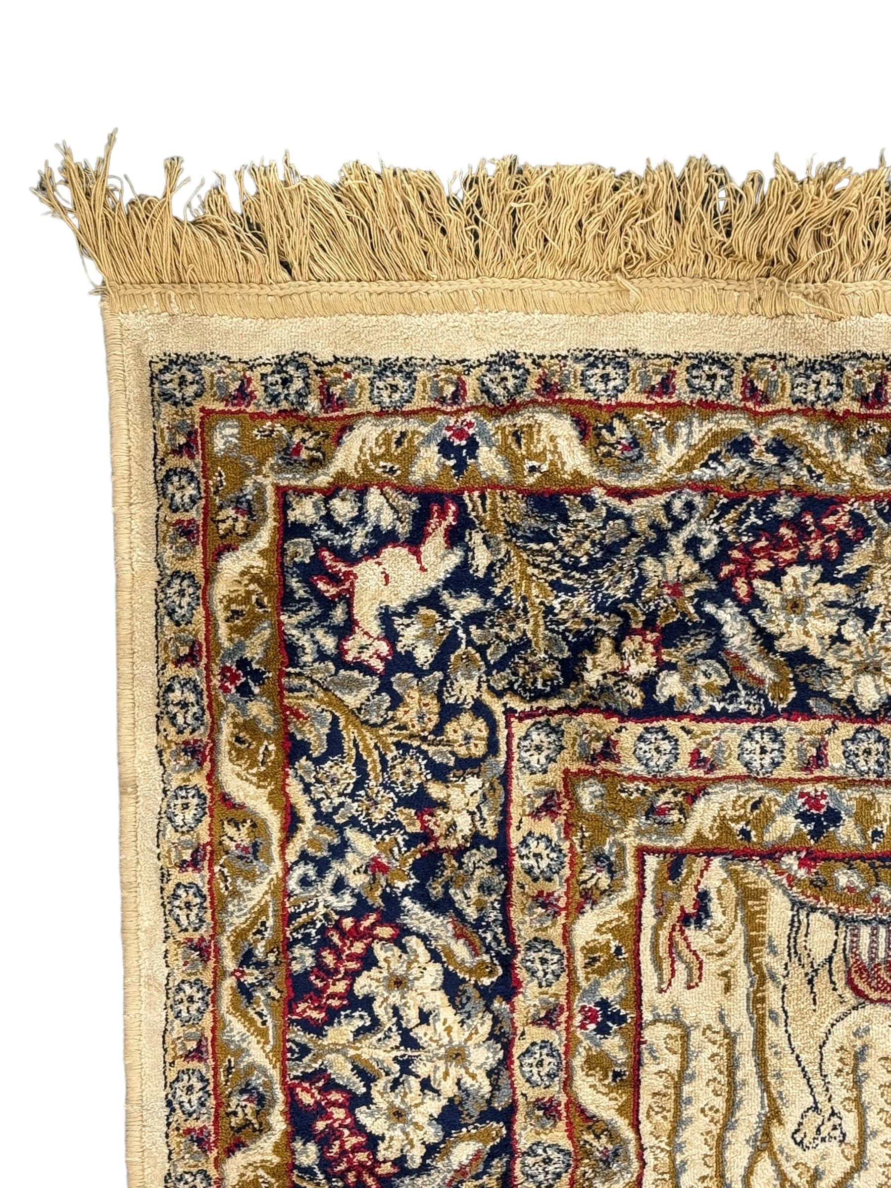 Persian Kerman ivory ground rug, the field adorned with naturalistic depictions of birds, animals and floral designs, framed by a multi-band border in blue and red tones