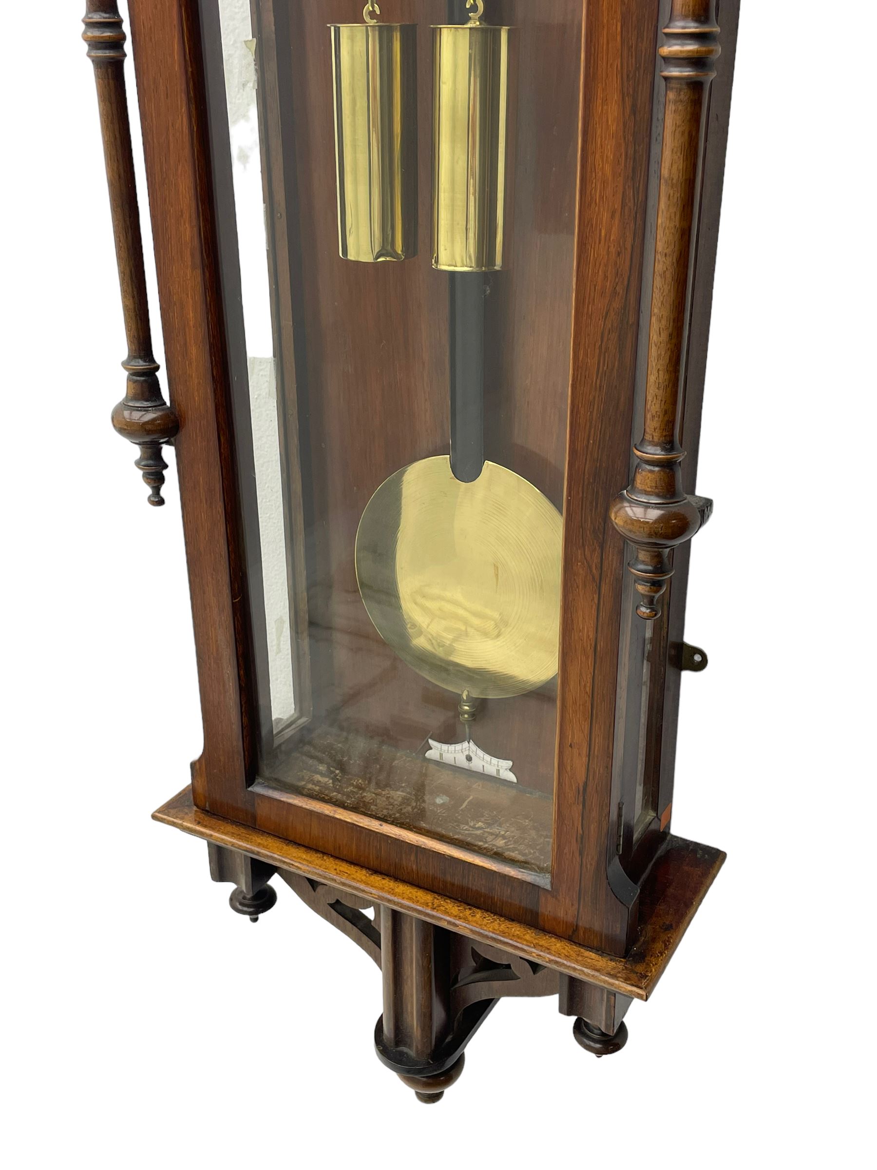 Lenzkirch – 8-day walnut cased weight driven Vienna regulator manufactured 1877-1878, with a break-arch pediment surmounted by a turned finial on a raised cavetto molding, fully glazed arched  door flanked by long ring turned pendants, flat base with open fretwork and two short pendants,  two piece enamel dial within a brass slip, Roman numerals, minute track and pierced steel hands, wooden pendulum with a brass faced bob, two brass cased weights and pulleys, dead beat escapement with a rack striking movement sounding the hours and half hours on a coiled gong, movement serial number 421410. 
Lenzkirch were one of Germanys most highly respected clock manufacturers of the 19th century, founded in the late 1850s the company produced movements and cases of high quality up until 1932.
