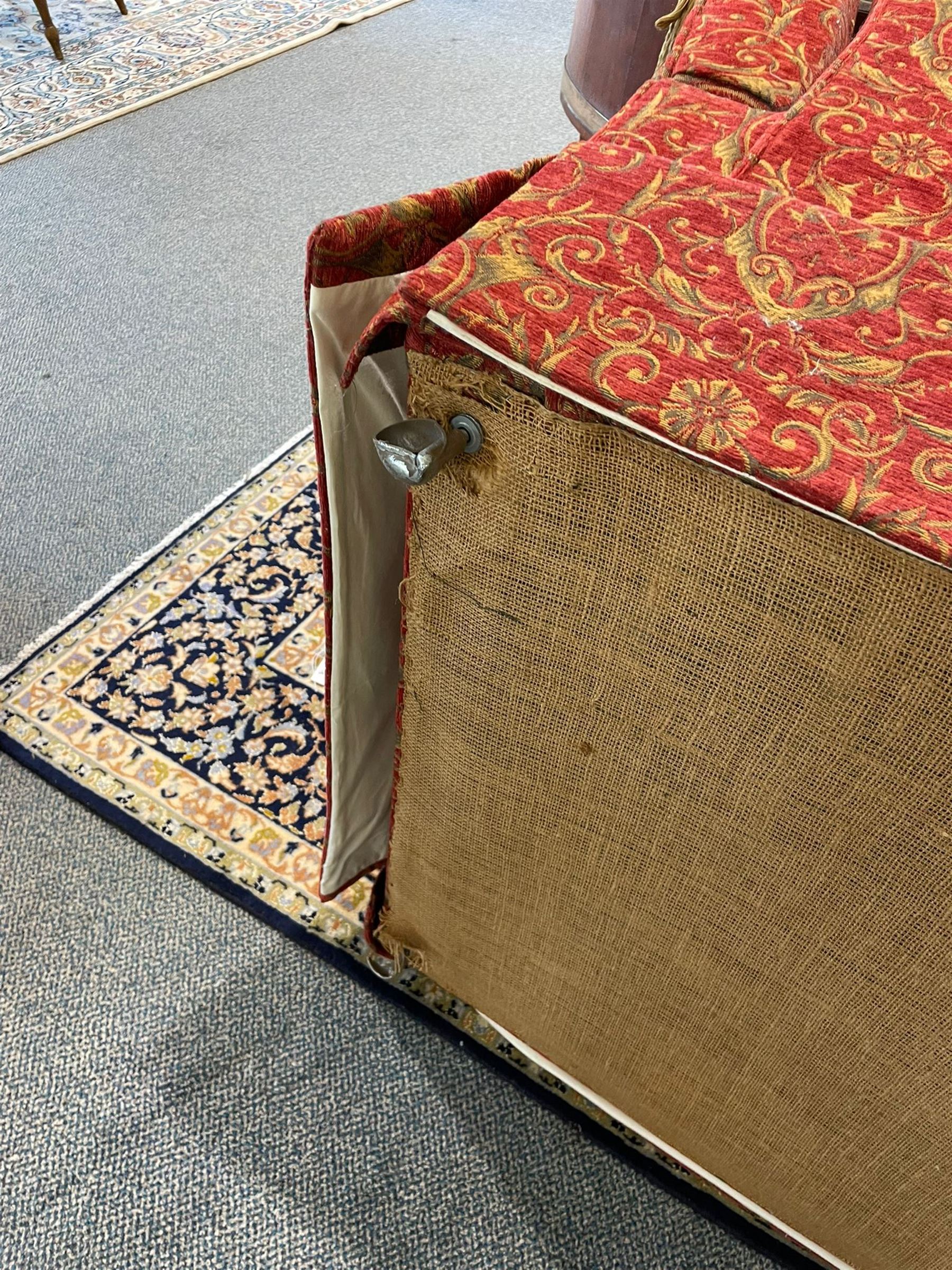 Large Knole design hardwood-framed three-seat drop-arm sofa, upholstered in crimson fabric decorated with trailing acanthus leaves and shields, together with scatter cushions 