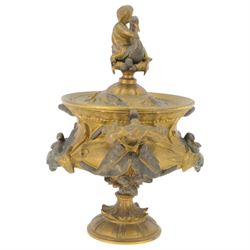 19th century gilt bronze twin handled urn, the removable cover with foliate decoration and finial modelled with a putti and swan, the body decorated in relief with swans and reeds, upon a circular foot, H19cm
