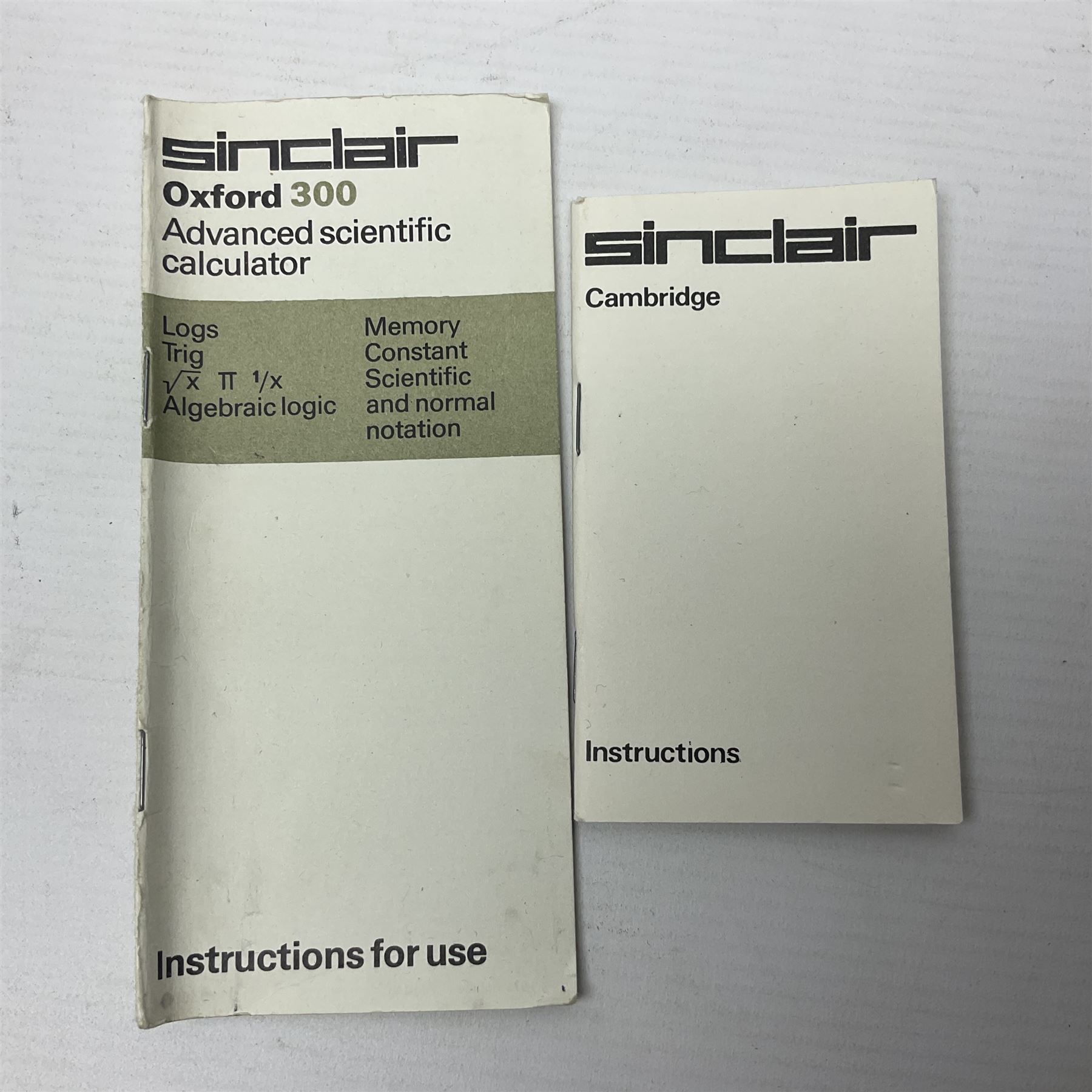 Four 1970s Sinclair electronic calculators - Cambridge in hard case with booklet; Scientific Programmable with Program Library and booklet; Scientific in hard case; and Oxford 300 in soft case with booklet; together with Texas PC-100 SR56 programmable slide-rule calculator on base station with readout, two booklets, keys and cover, serial no.9103093