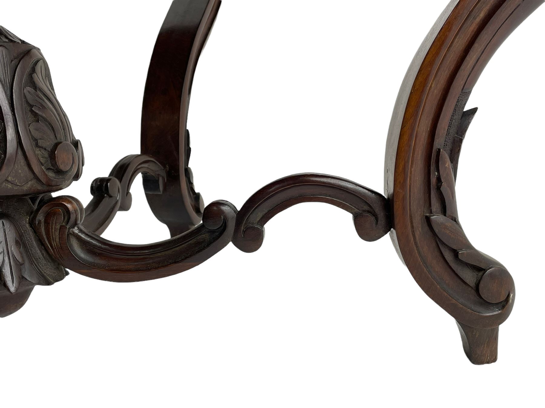 19th century Irish rosewood centre table, the shaped and moulded top over shaped apron carved with scrolled foliage, on serpentine supports carved with bell flowers, the supports united by anthemion carved finial and s-scroll x-framed stretchers