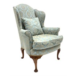 Late 20th century Queen Anne style walnut wingback armchair, curved front rail with sprung seat and seat cushion, shell carved cabriole feet with fluted detail, with additional cushion