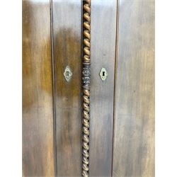 Early 20th century Italian walnut armoire wardrobe, the pierced and scrolling pediment carved with acanthus leaf detail, flanked by two scrolling cartouche with matching corbels below, the two panelled doors with applied carved rinceaux slips, with a central spiral turned upright, enclosing single shelf and hooks, raised on scroll feet