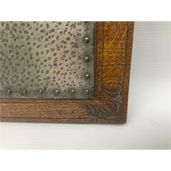 Arts and Crafts oak stand by Arthur Simpson of Kendal, of rectangular form with central hammered pewter panel, surrounded by a border with carved foliate corners, upon two bar supports, bearing label detailed 