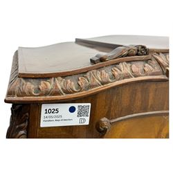 Early 20th century walnut veneered cocktail cabinet, shaped and carved foliate pediment above a pair of arched panelled doors with figured veneers and ornate cast escutcheons, interior is mirrored on the base and back, slide out mirrored shelf, flanked by foliate carved uprights, over a conforming lower cabinet, all raised on shaped apron and scroll carved cabriole feet