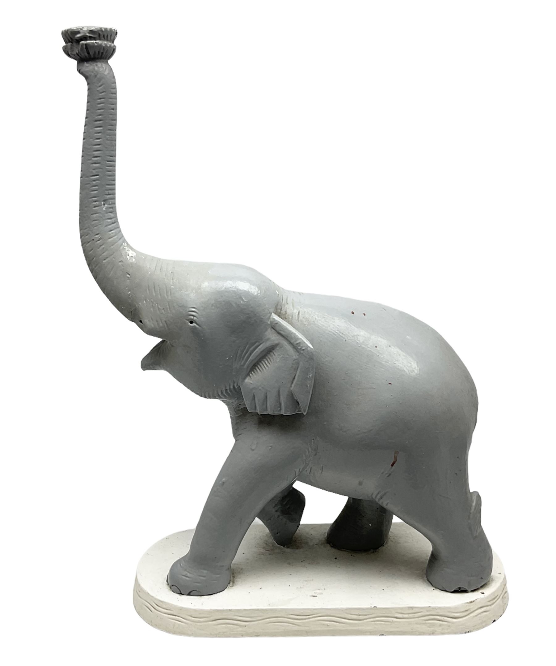 Composite figure of an elephant, painted grey, upon white base, L45cm H65cm