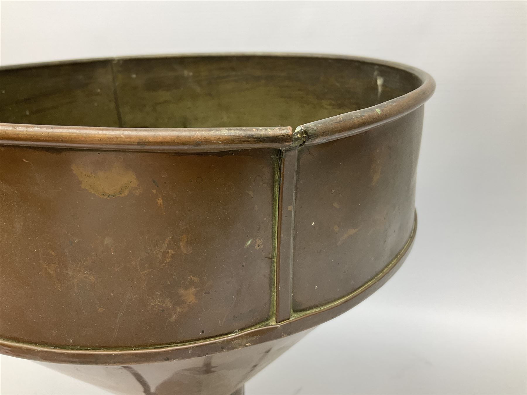Agricultural copper corn funnel, H32.5cm, another similar copper funnel and copper warming platter of oval form, with twin handles on four supports, with removeable warming plate, L49cm