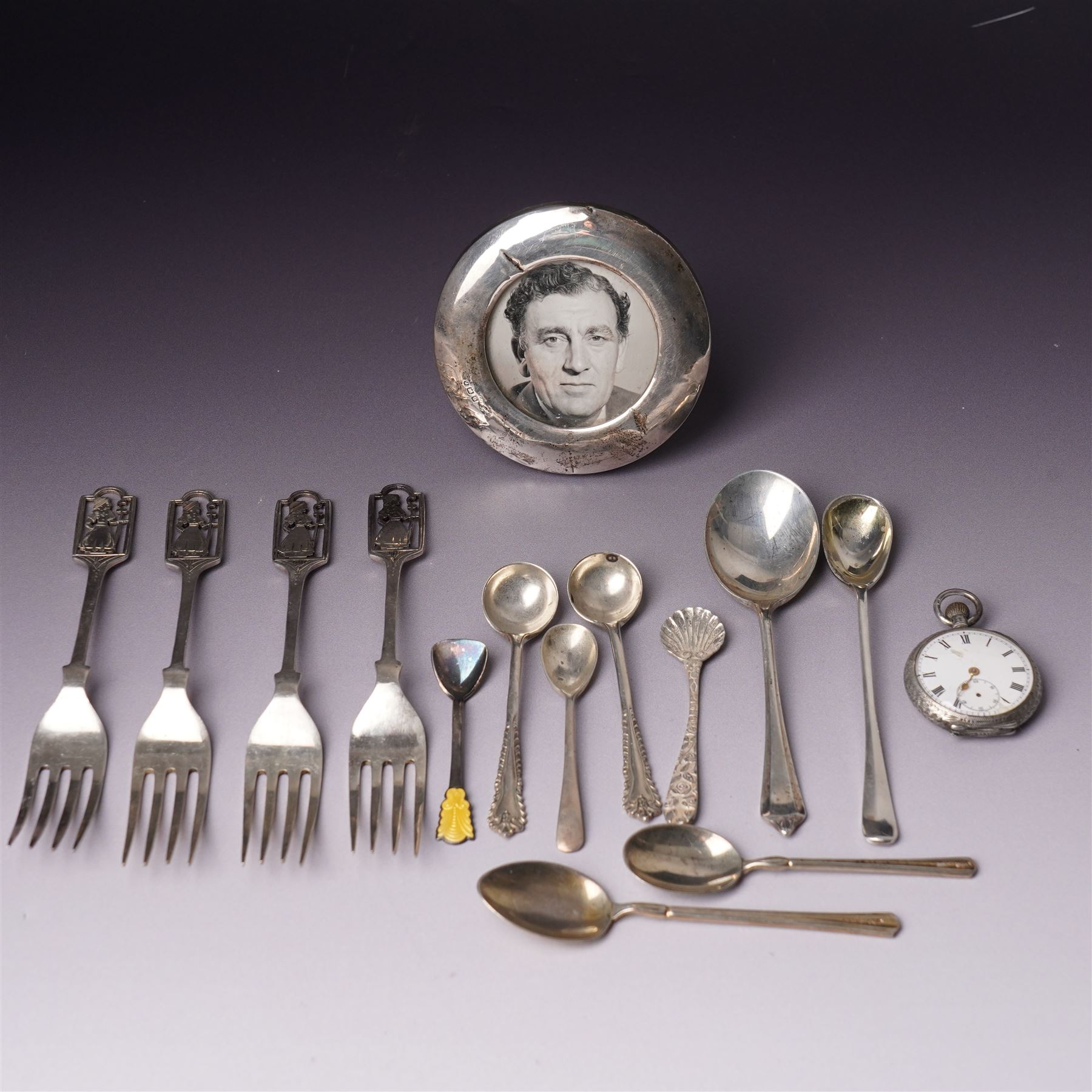 Small silver photograph frame,  four decorative silver forks, two silver and enamel spoons, other silver spoons and silver cased fob watch 