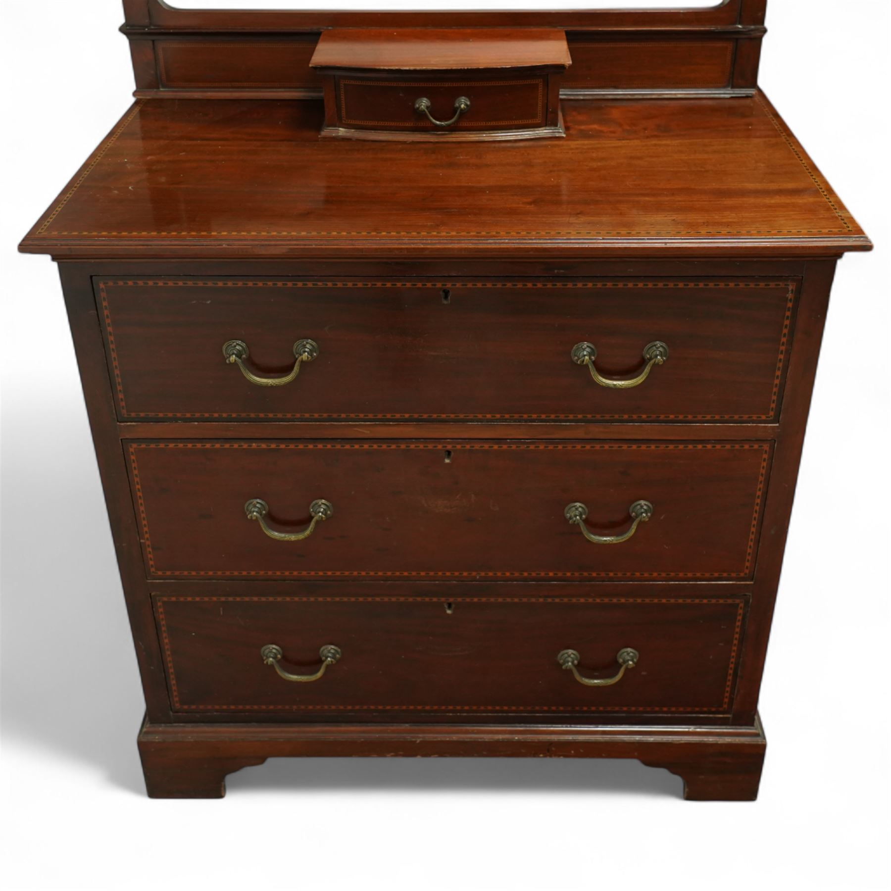 Edwardian mahogany herring-bone inlaid dressing chest, with swivel bevelled dressing mirror, supports with finials, and trinket drawer above chest with three graduated drawers on bracket feet