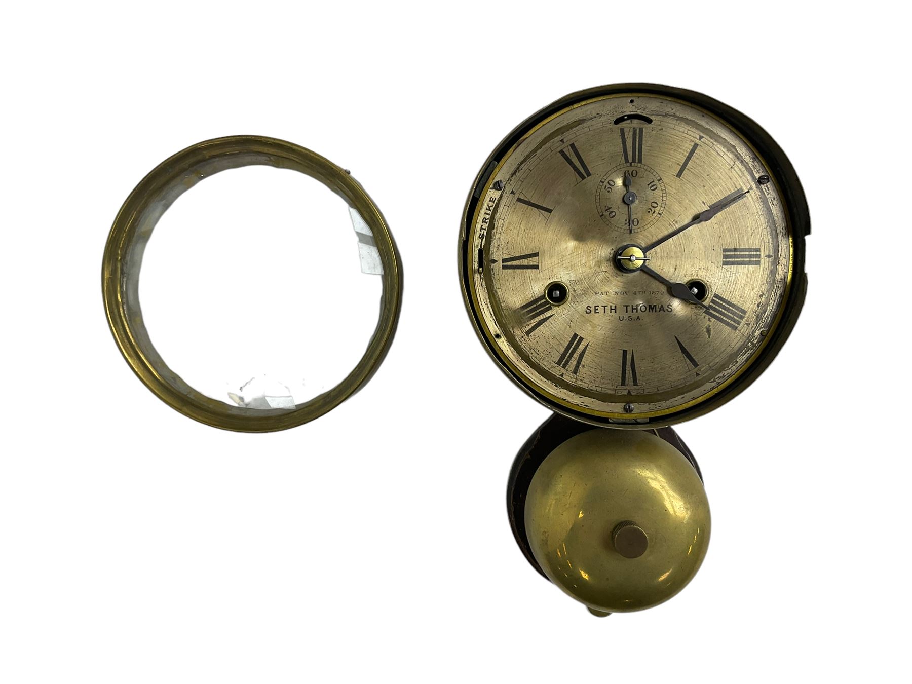 Seth Thomas U.S.A. Ships clock c1890, with a 6” silvered dial sounding the ships watch on a brass bell, eight-day twin train balance wheel movement, silvered dial with Roman numerals, steel spade hands, escapement regulation and subsidiary seconds dial, with a circular alloy drum case mounted on a wooden plaque, dial inscribed “4th November 4th 1879  Seth Thomas U.S.A.