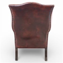 Georgian design wingback armchair upholstered in oxblood leather, the deep button upholstered back with shaped wings and out-scrolled arms, close nailhead trim to the edges, over a loose seat cushion, raised on cabriole front supports terminating in claw and ball feet