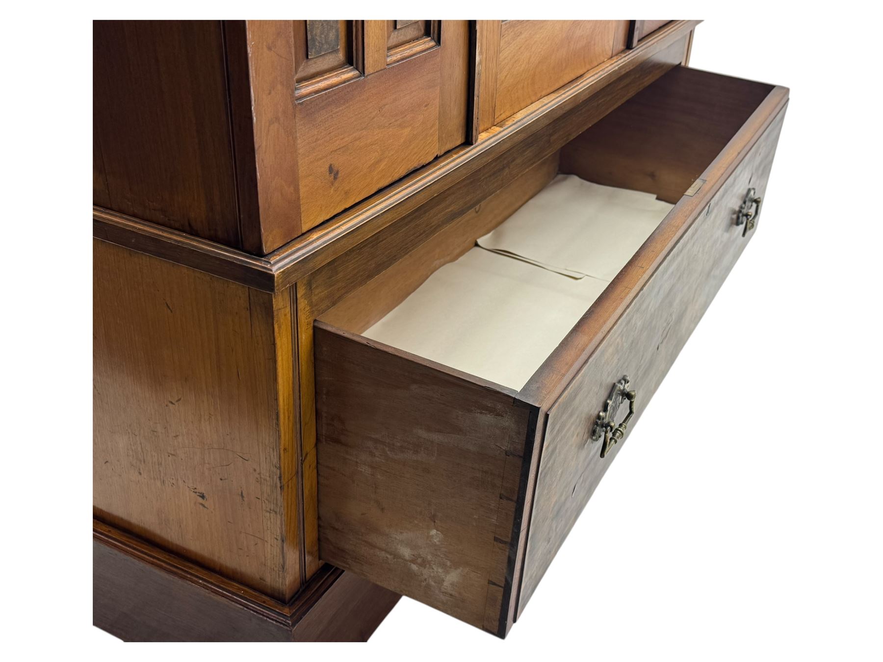 Victorian walnut bedroom suite - wardrobe, dressing chest and bedside cupboard, comprising a full-length wardrobe with broken pediment and central mirrored door, large lower drawer, a matching dressing table with bevelled swing mirror over two trinket drawers and two short drawers over two long drawers, and a single-door bedside cupboard, all with moulded edges, decorative panel work and shaped aprons