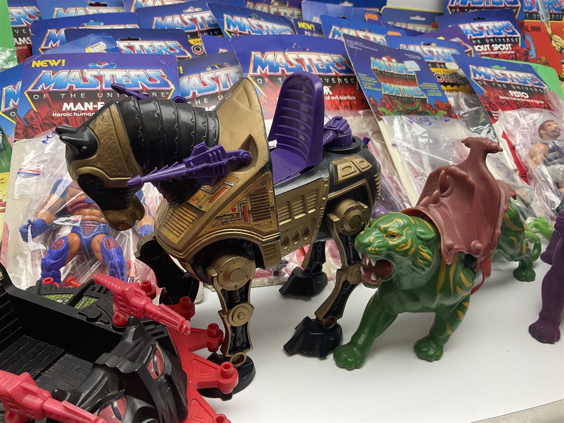 Thirty-one Masters of the Universe He-Man figures re-bagged on original backing cards;  two others lacking backing cards; boxed Modulok figure; bag of weapons and accessories; Roton, two horses and two battle cats; 1986 & 1987 Annuals; Ladybird and other story books; Panini sticker album; instructions etc