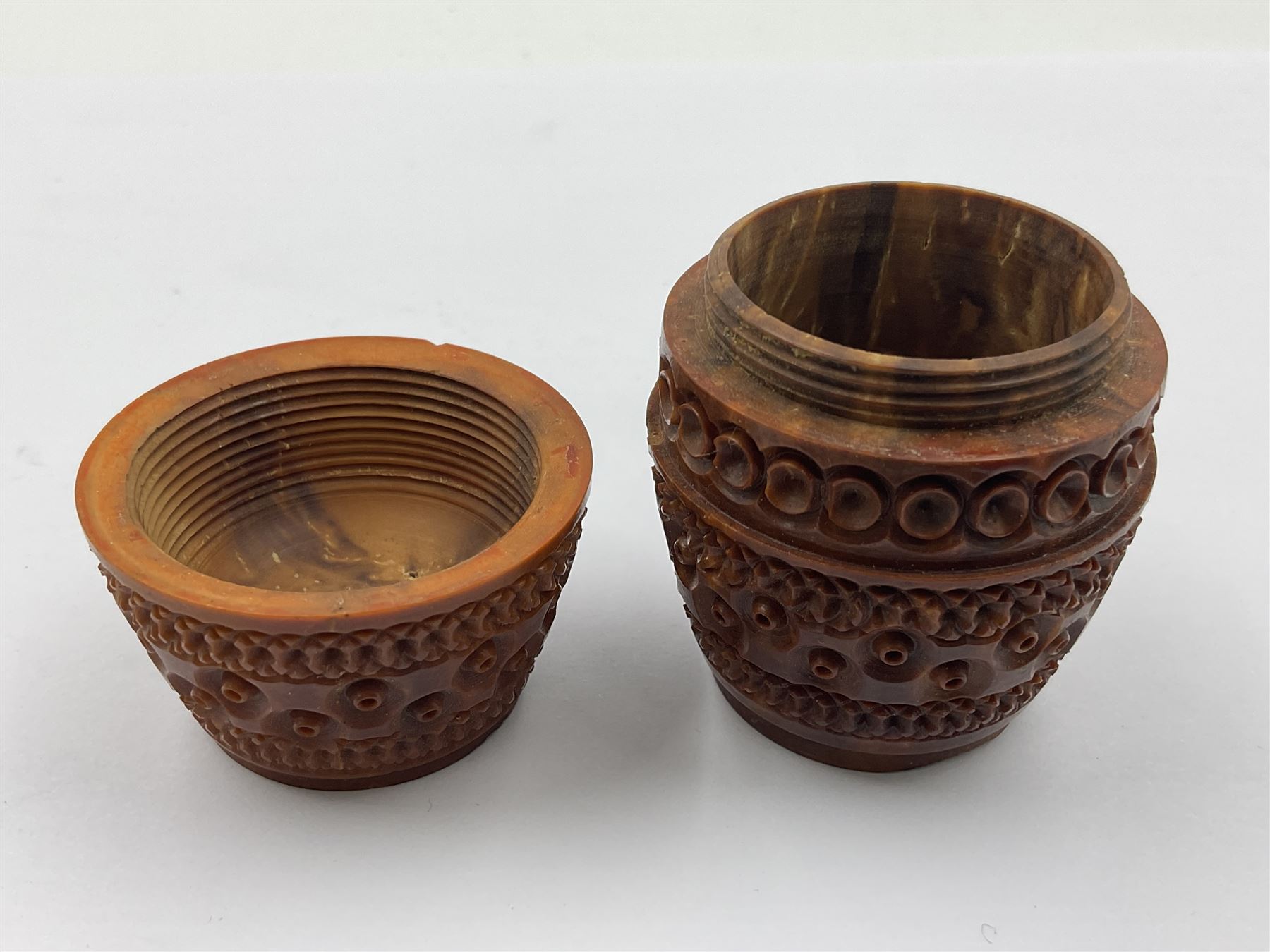 Three 19th century coquilla nut pomanders or flea catchers, two of egg shaped form and the third of barrel from with carved and pierced decoration and screw threaded join, largest H8cm