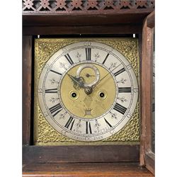 John Watts of Canterbury - early 18th century 8-day oak longcase clock, with a flat topped hood, broad cornice, dentil moulding and blind fret beneath, baluster turned pilasters with wooden capitals flanking the square hood door, trunk with recessed beaded edge and a long ogee topped door with crossbanding, plinth with applied skirting, square brass dial with matching steel hands, cast spandrels and a matted and engraved centre, date aperture, seconds ring and ring turned winding apertures, silvered chapter ring with Roman numerals, five minute Arabics, minute and quarter hour tracks, five pillar movement with a recoil anchor escapement and inside countwheel strike, sounding the hours on a bell. With weights and pendulum.