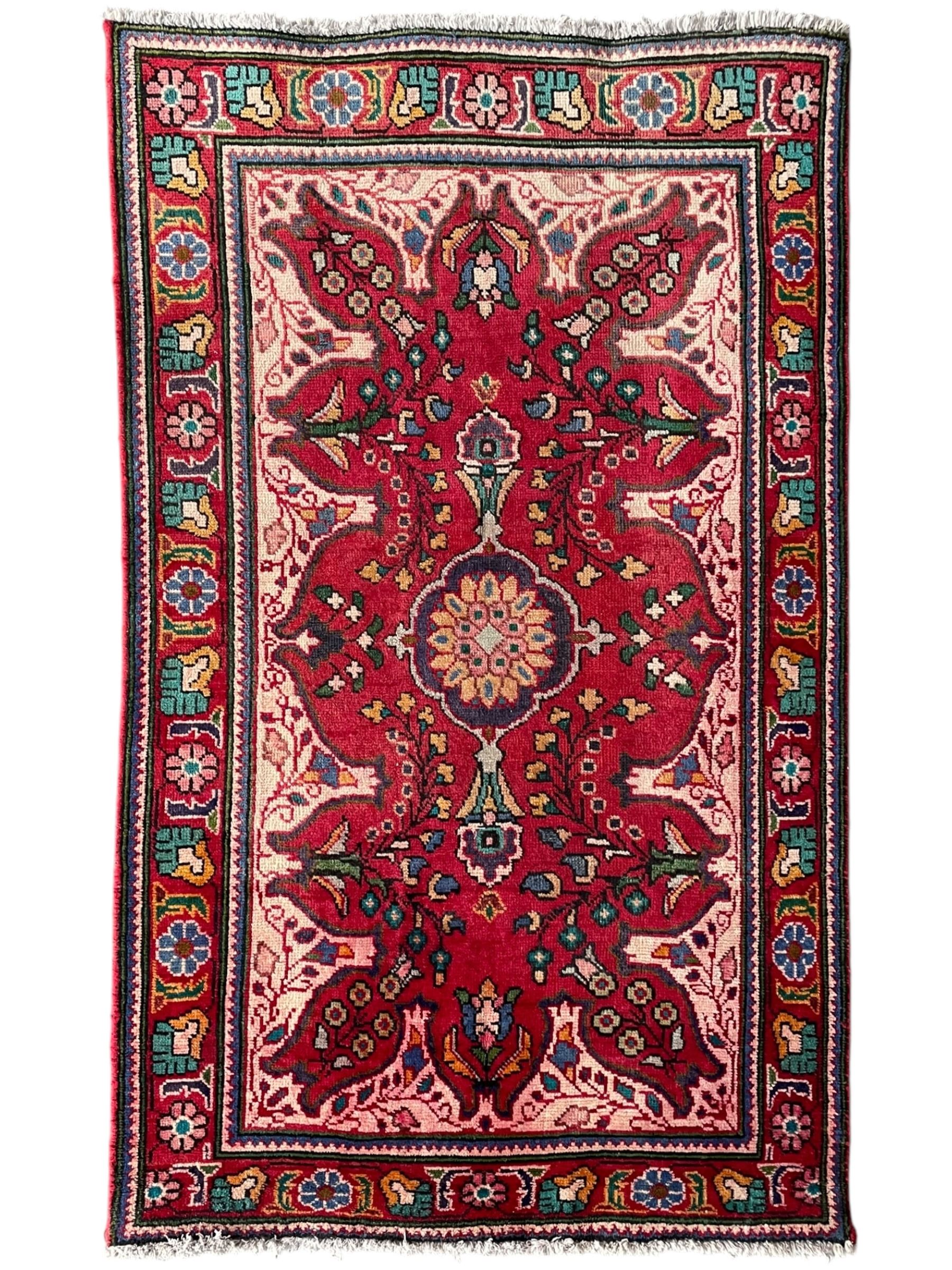 Persian Azerbaijan crimson ground rug, the field decorated with central floral motif and surrounded by trailing floral branches, enclosed within a shaped outer band with further floral decoration, the border with repeating flower heads, geometric guard stripes
