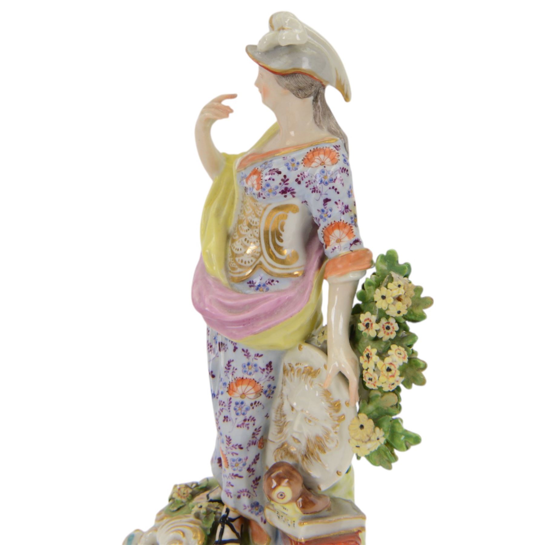 18th century Derby porcelain figure, circa 1775, modelled as Minerva, standing with mask shield, books and owl, against flowering bocage, upon a scroll base encrusted with flowers, H23cm