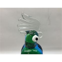 Three Murano style glass cockatoo parrots, the first with mottled yellow, red and orange body, clear outstretched wings, dark blue beak and red crest, raised upon clear stylised base, the second smaller parrot with merging blue and green body, and further with pink striped body, tallest H40cm