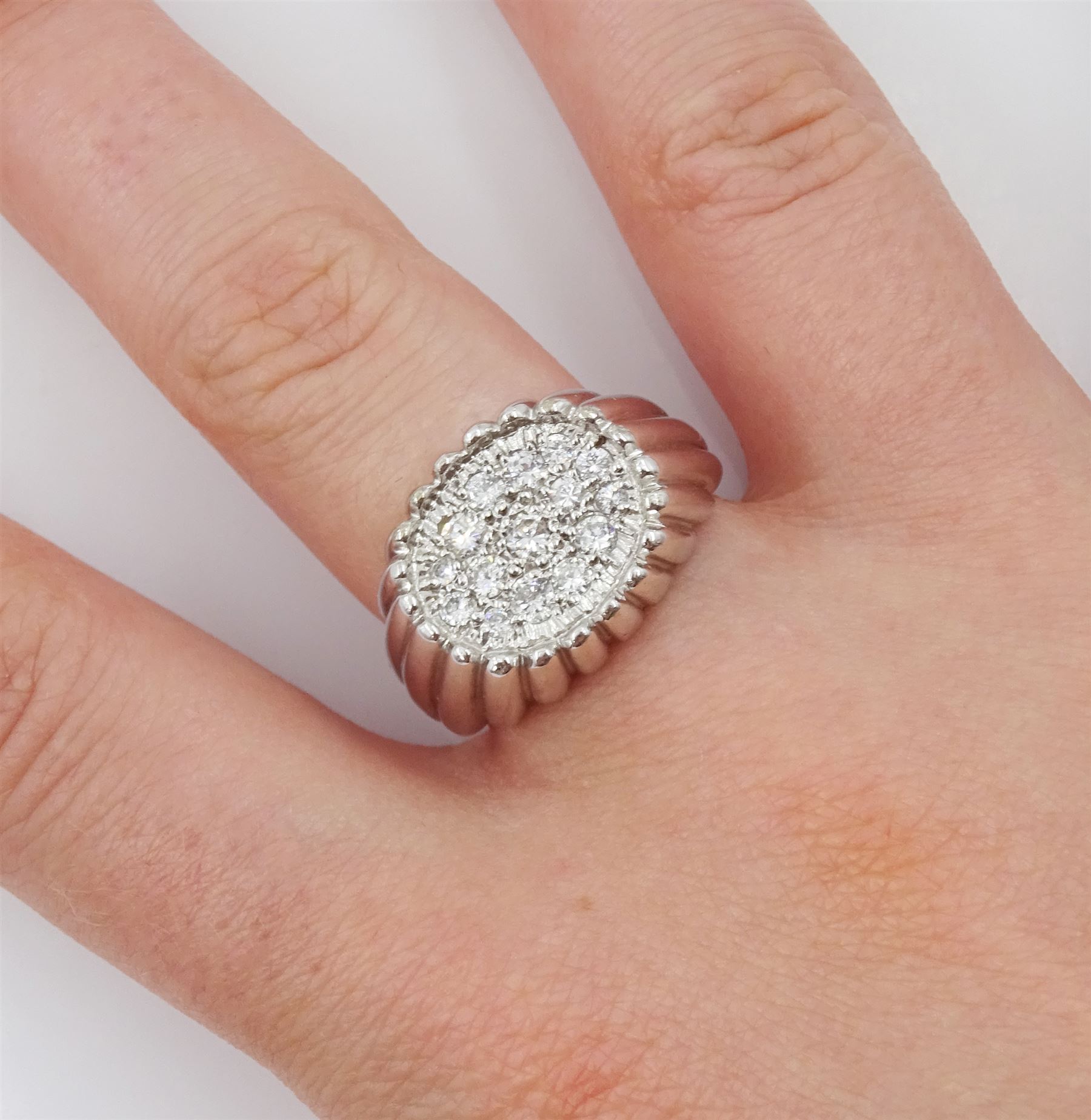 White gold diamond ring, fifteen pave set round brilliant cut diamonds, in an oval setting, stamped 18ct, total diamond weight approx 0.70 carat