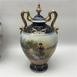 19th century Vienna style porcelain 'Musik' garniture, the central vase of baluster form with domed cover flanked by two smaller vases with twin curved gilt handles to short neck, each decorated with classical figural vignettes between blue borders heightened with gilt, H33.5cm