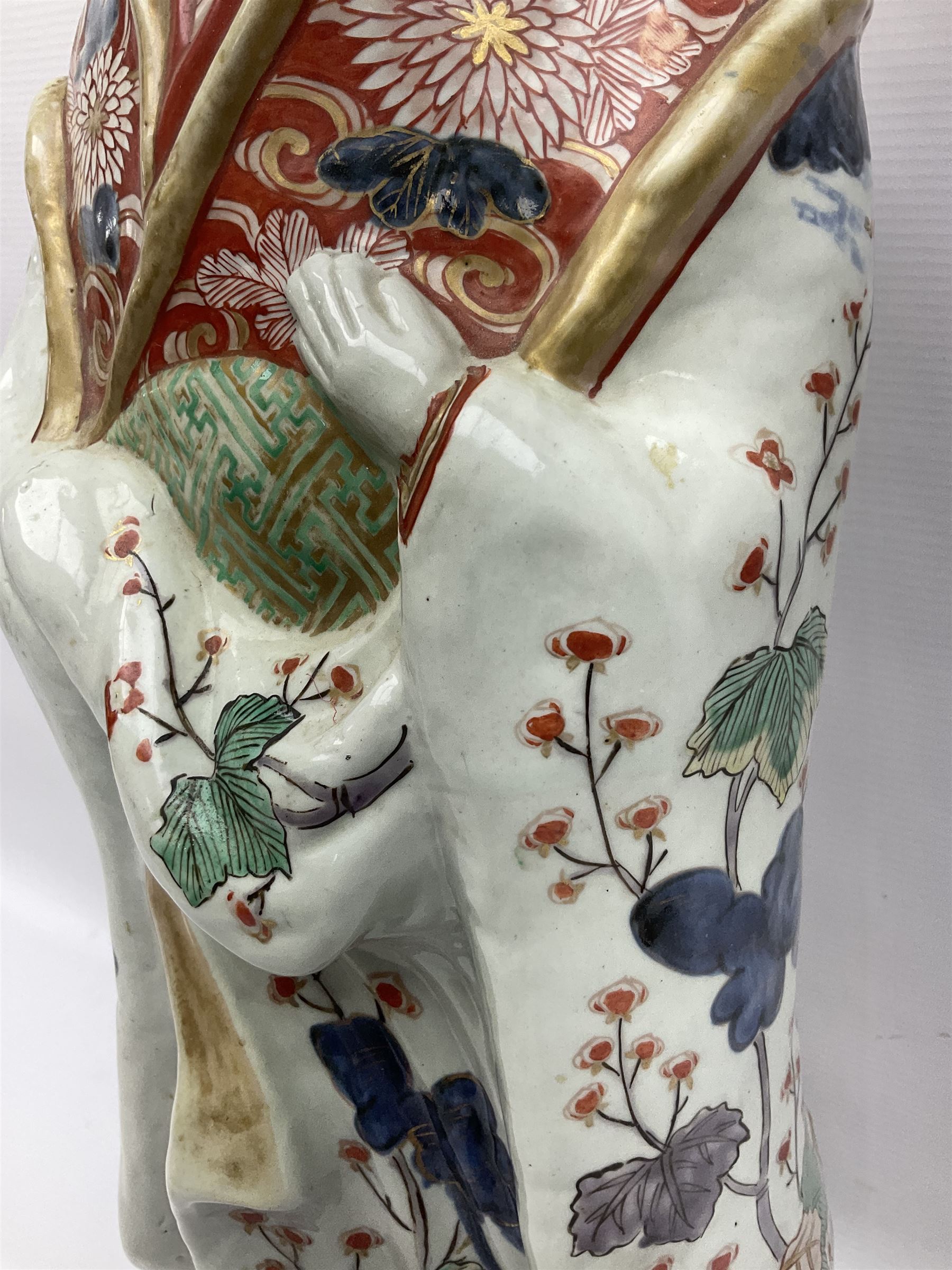 Large Japanese Imari porcelain figure, modelled as a Bijin, wearing a long kimono decorated with apple blossom and leafy branches on a white ground, with gilt detailing, possibly Edo period, H63cm
