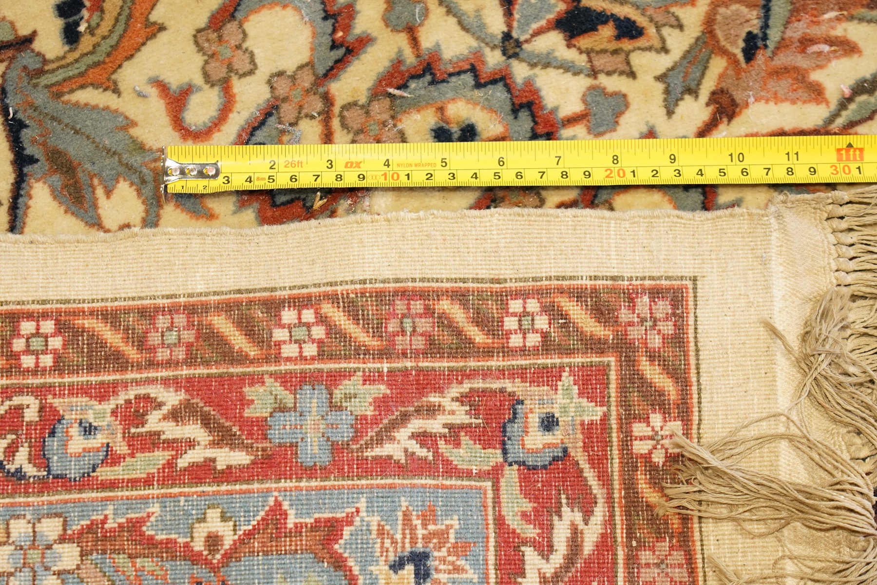 Persian Isfahan ivory and crimson ground rug, the busy field with central floral pole medallion surrounded by foliate motifs and stylised palmettes, the indigo guard line with repeating scrolling plant motifs