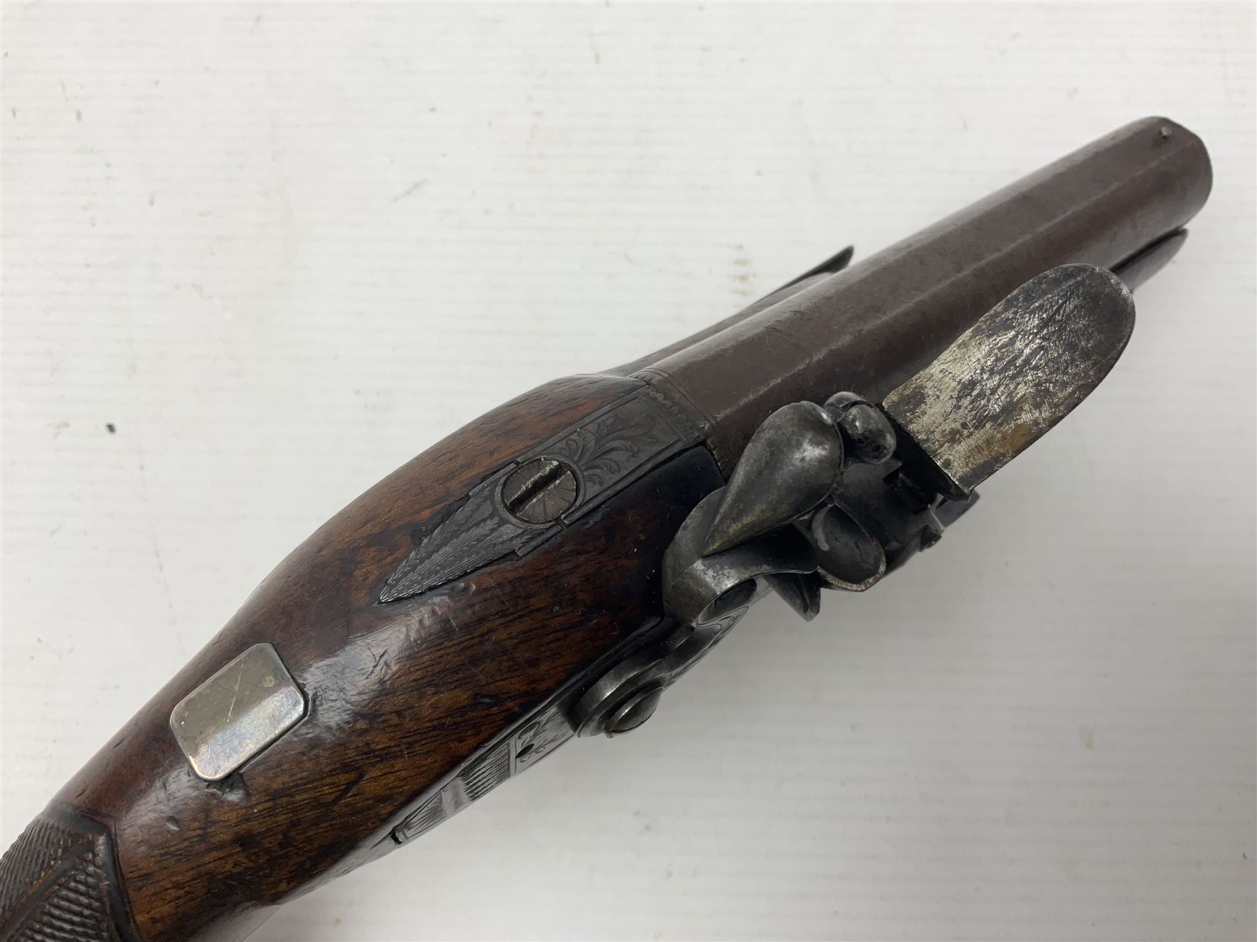 Early 19th century Wm. Hollis flintlock belt or pocket pistol, approximately 20 bore, the 10cm barrel with ram rod under, engraved lock plate with maker's name and roller frizzen, engraved trigger guard with pineapple finial and walnut stock with chequered grip L25cm overall