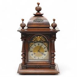 German-Junghans late 19th century oak cased mantle clock, with a domed pediment and three matching turned finials, break arch door beneath with attached turned and tapered pilasters, brass dial with cast spandrels, matted dial centre, steel hands and silvered chapter ring with Roman numerals, two train movement striking the hours and half-hours on a coiled gong. With pendulum and key.