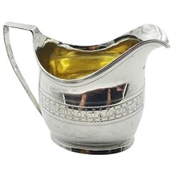 George III silver cream jug, of oval helmet form with strap handle, the body engraved with vacant shaped panel and foliate band, hallmarked London 1803, makers mark worn and indistinct, H10cm, approximate weight 4.44 ozt (138.2 grams)