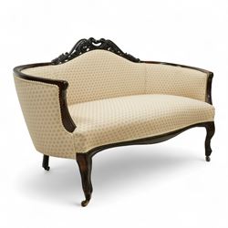 Victorian mahogany upholstered settee, the shaped back with pierced foliate carved cresting, upholstered in cream patterned fabric with serpentine seat, on cabriole front legs with brass castors