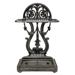 Victorian style cast iron umbrella and stick hall-stand, arched and scroll cast pediment over lyre shaped back, decorated with flower heads, moulded base with removable drip tray 