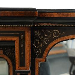 Victorian amboyna and ebonised credenza with glass top, the freeze fitted with two Wedgewood plaques and brass beading above crossbanded arched glazed mirror door flanked by two glazed cabinet doors with two removable glass shelves between four gilt brass reeded floral columns, supported on bun style feet