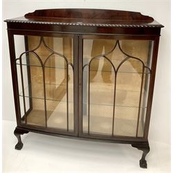 Early 20th century mahogany bow front display cabinet, raised shaped back, two doors enclosing two lined shelves, cabriole legs on ball and claw feet 