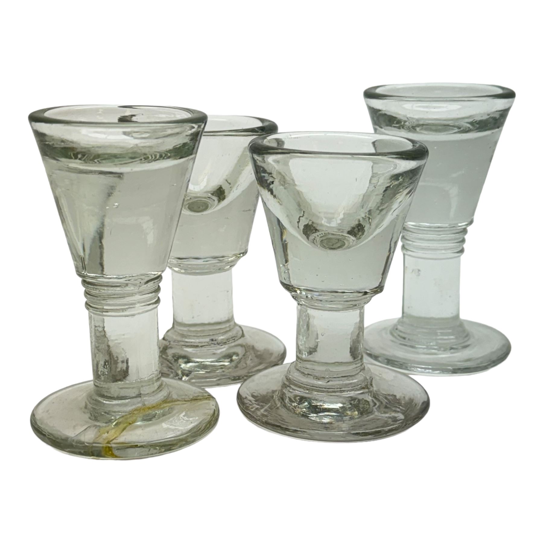 Five 19th century penny lick glasses, together with a pair of 19th century cut glass open salts with lemon squeezer bases, and a 19th century glass measure, largest example H12cm