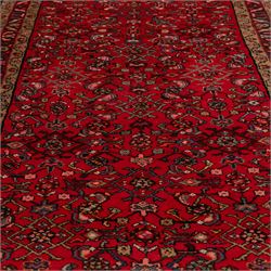 North West Persian runner, the red field decorated with an all-over Herati pattern of diamond lattice motifs, rosettes and serrated leaves, ivory floral spandrels, enclosed by an indigo palmette border and narrow floral guard bands