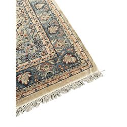 Persian ivory ground rug, central floral pole medallion surrounded by scrolling foliate branches and swirls, with matching pale blue spandrels, the guarded blue border decorated with repeating palmettes 
