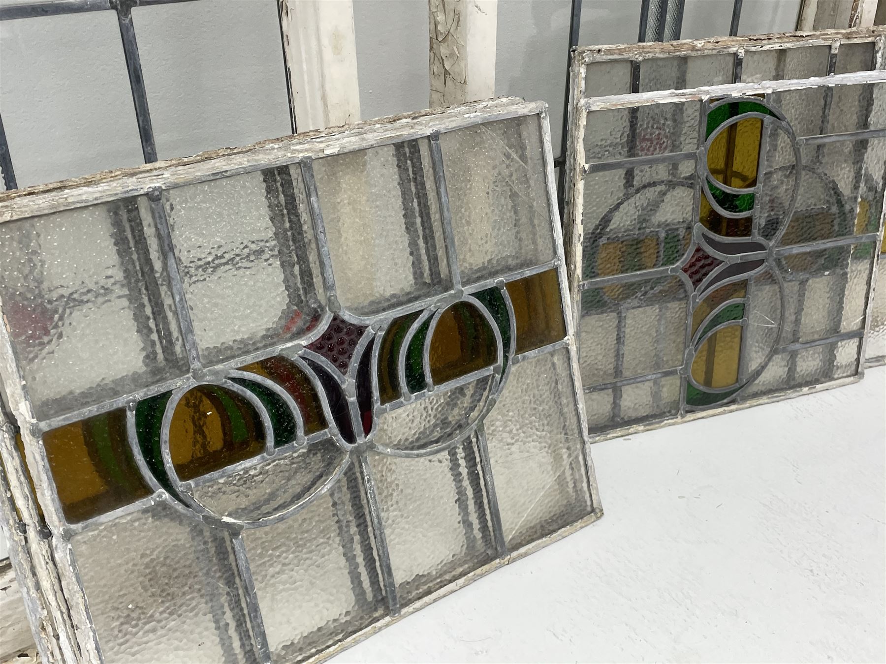 Collection of stained and leaded glass windows and panes, stylised floral design, various sizes, the largest window measuring 55cm x 112cm (including wooden frame)