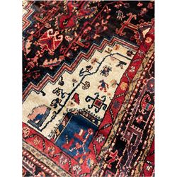 Persian Hamadan rug, with central pole medallion on dark field decorated with stylised motifs, ivory ground spandrels, multi-band border decorated with trailing stylised motifs 