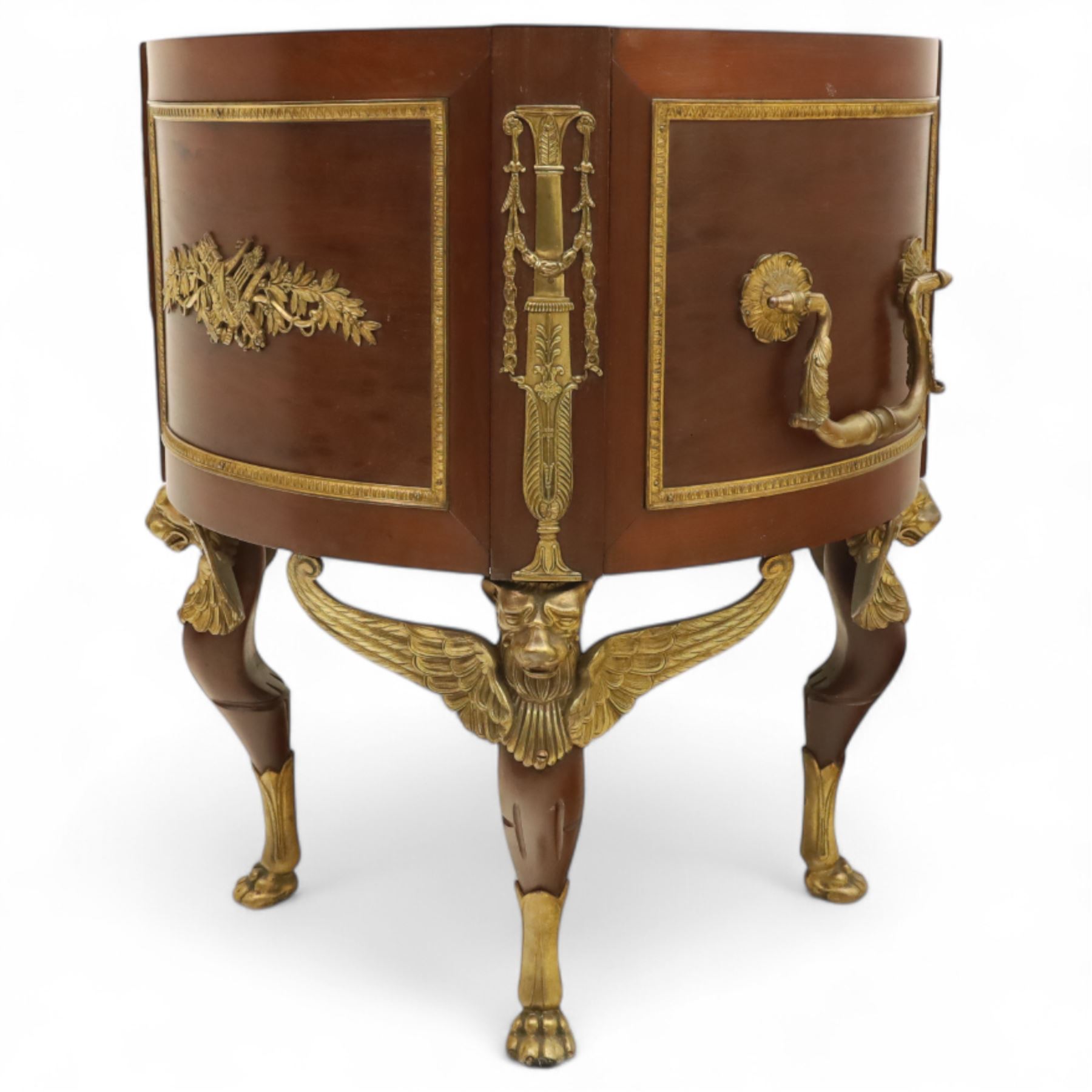 An imposing and richly adorned Empire Revival jardiniere of circular form, decorated with finely cast gilt bronze laurel garlands and floral swags, interior with a modern brass liner, sides with gilt bronze carrying handles, raised on three tripod legs with classical caryatid masks with wings terminating in lion paw feet, circa 1900

Provenance: This jardiniere formed part of the original furnishings of the opulent Empire Room at Kinloch Castle, built by industrialist George Bullough in 1900.

An original inventory number, ‘X954’, is inscribed on one facing, verifying its presence in the Kinloch Castle collection. This jardiniere epitomises the lavish taste of the Edwardian elite and the high standards of craftsmanship employed in the furnishing of Kinloch Castle, the first private home in Scotland to be lit by electricity and famed for its extravagant interiors.


