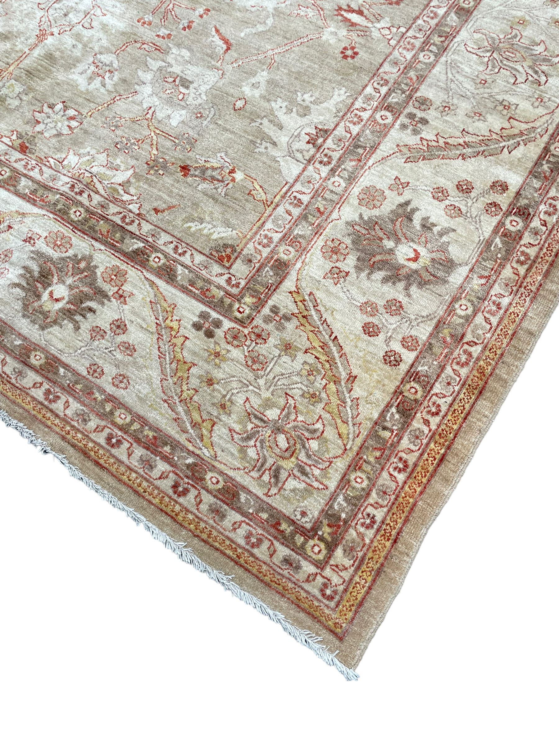 Pakistani ivory ground carpet, the field decorated with leaf branches, lotus flowers and roses, wide guarded border long leaves and stylised plant motifs