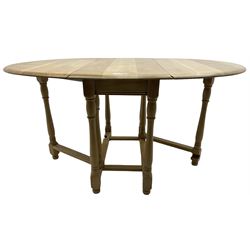 Contemporary oak and beech dining table, oval drop-leaf top on turned supports united by stretchers, gate-leg action base